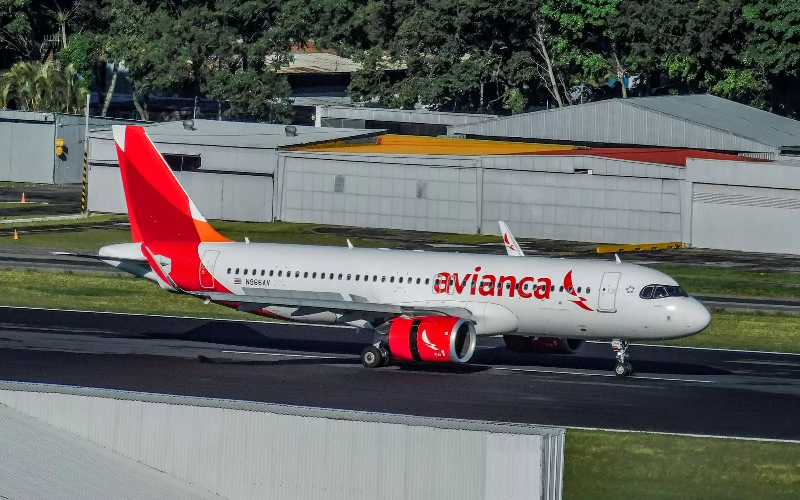 Airbus A320neo blanco con cola roja y naranja de Avianca Costa Rica rodando por la pista de un aeropuerto