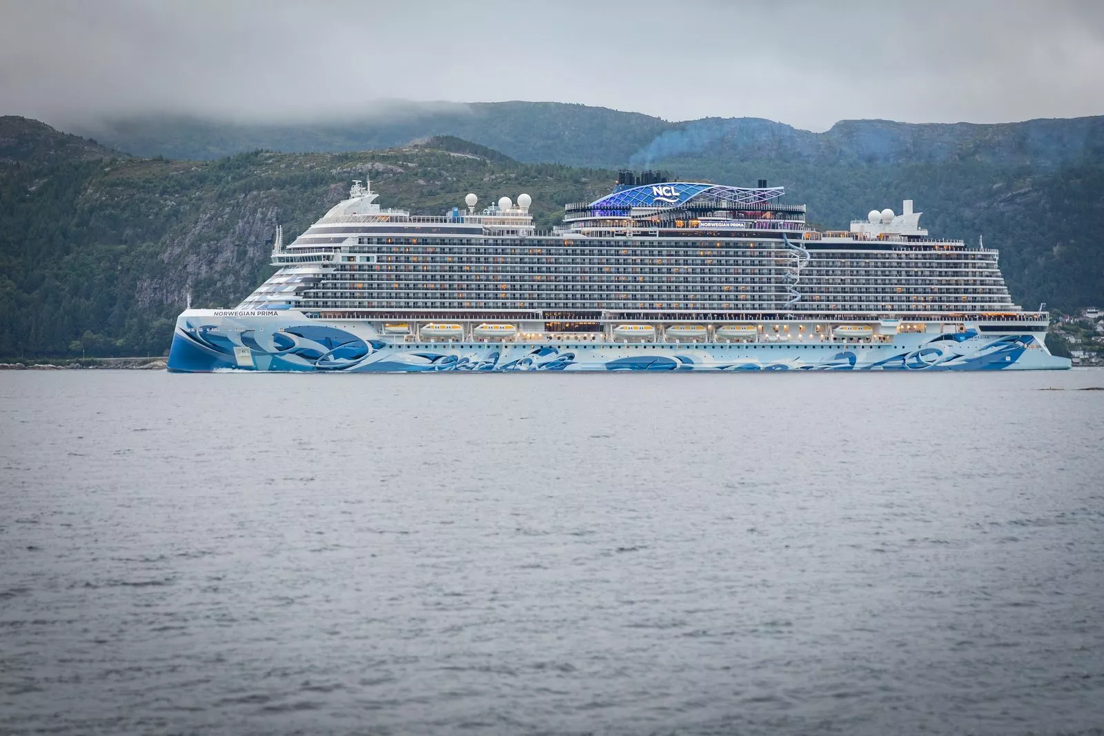 El crucero Norwegian Prima pasa frente a la costa de Husevåg, en el fiordo Nordfjord, Noruega